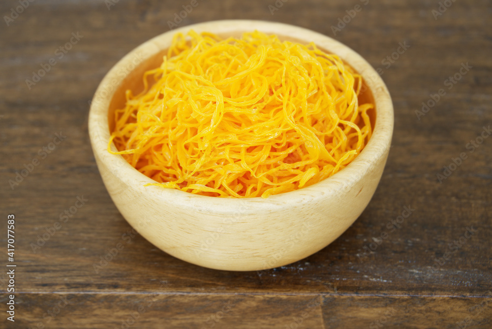 Foi Thong (Golden Egg Yolk Threads) In a wooden cup close up Foi Thong (Golden Egg Yolk Threads) In a wooden cup close up