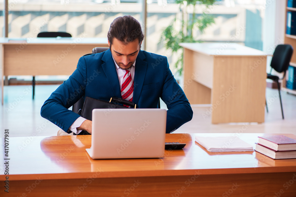 Young handsome employee working in the office