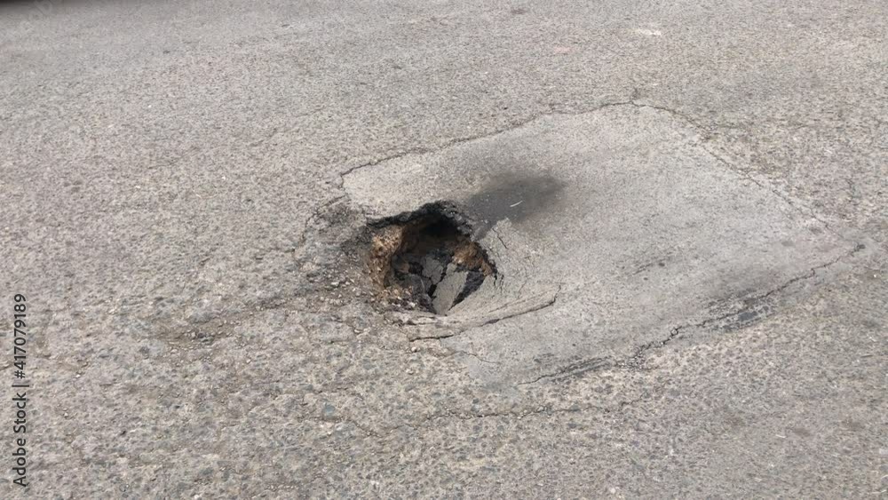 closeup of a car stepping on a gap in the road. Truck tires falling