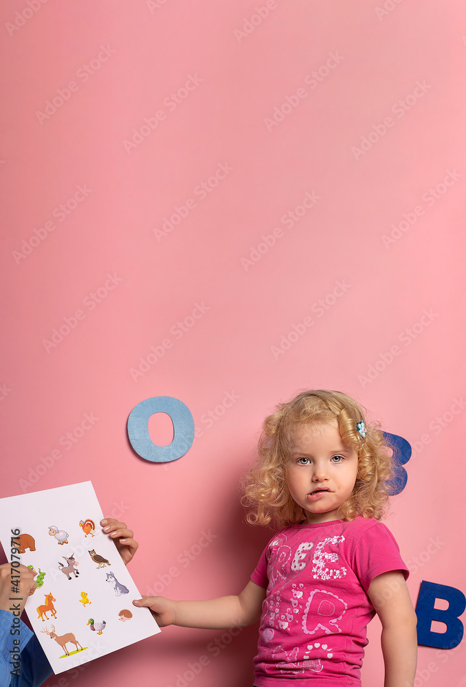 Portrait of little girl of 2-3 years on speech therapy.Concept over pink background Portrait of little girl of 2-3 years on speech therapy.Concept over pink background