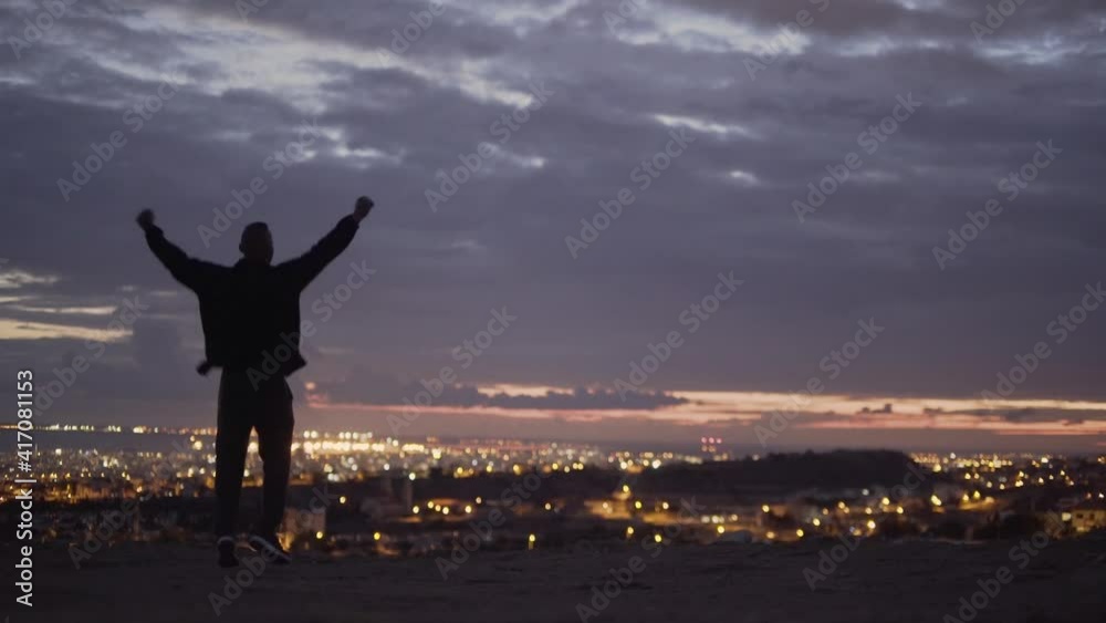 Silhouette of young man jumping with happiness at dusk
