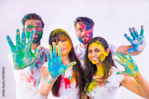four happy best friends having great traditional holi time together in white background studio