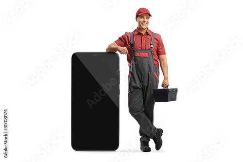 Принти на полотні Mobile phone repairman leaning on a big smartphone and holding a tool box