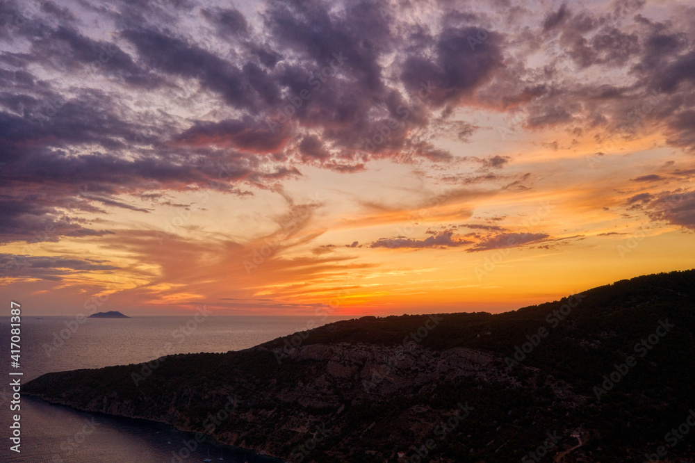 Aerial drone shot of sunset burning sky clouds over Vis Island in Croatia Summer