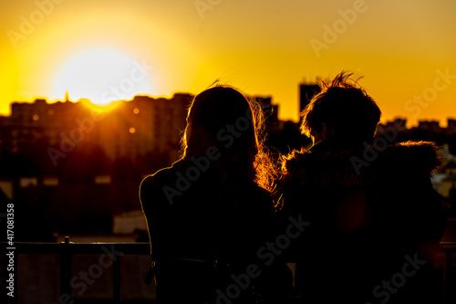 A couple is watching the sunset over the city from the observation deck in Warsaw, Poland