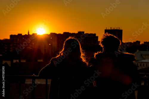 A couple is watching the sunset over the city from the observation deck in Warsaw, Poland