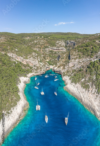 Fototapeta Naklejka Na Ścianę i Meble -  Aerial drone shot of yachts at Stiniva cove of blue Adriatic sea on Vis Island in Croatia summer