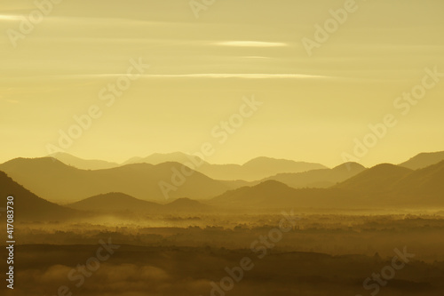 Landscape Arrange Mountains hill with mist fog in the morning sunrise - nature scenery from Phuthok Chaing Khan Loei Thailand , yellow nature image background and Backdrop