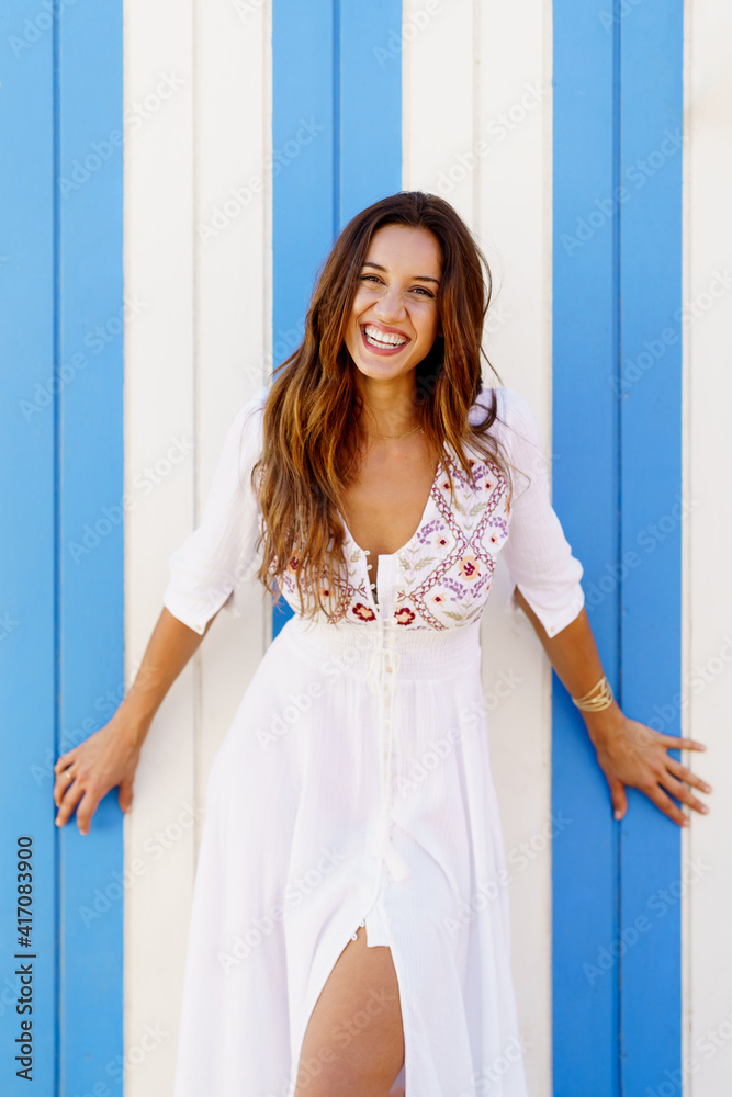 Young woman, fashion model, posing in front of a beach booth. Young woman, fashion model, posing in front of a beach booth.