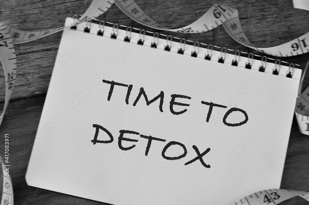 Top view of measuring tape and notebook written with text TIME TO DETOX. Top view of measuring tape and notebook written with text TIME TO DETOX.