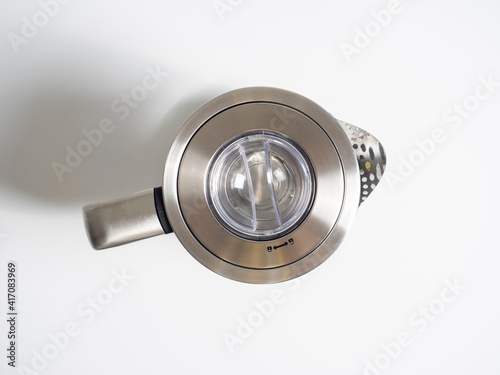 electric metal kettle in silver color on a bright white background. Top view, flat lay