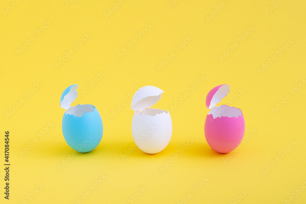 Creative minimal Easter concept with colorful empty eggshells on yellow background