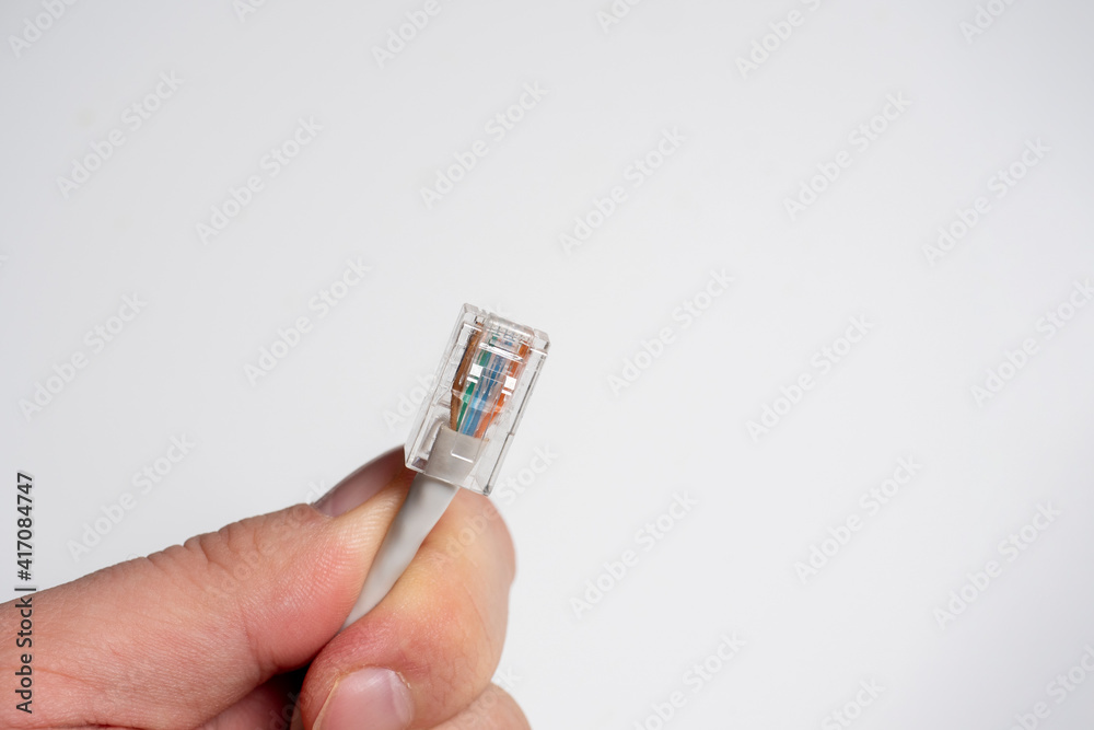 male hand holding communication cable patch cord rj45 on white background. Selective Focus male hand holding communication cable patch cord rj45 on white background. Selective Focus