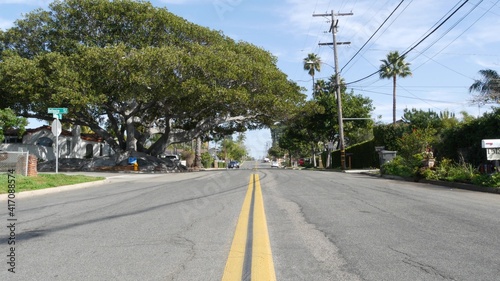 Houses on suburban street in California USA, Oceanside. Generic buildings in residential district near Los Angeles. Real estate property exterior. Tropical gardens, palms near typical american homes.