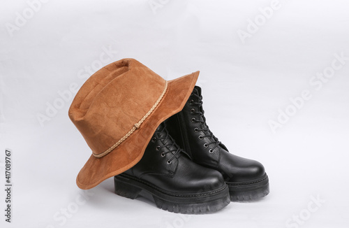 Black Fashionable high-soled leather boots and hat on white background