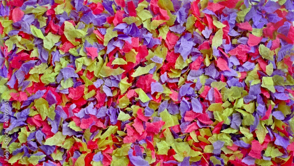 Obraz premium Bright multicolored pink yellow purple background of small pieces of crumpled parchment paper close up.