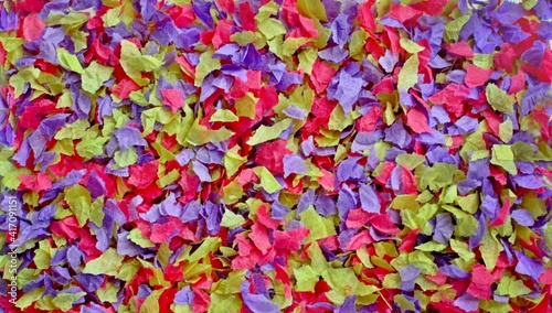 Bright multicolored pink yellow purple background of small pieces of crumpled parchment paper close up. © Irina