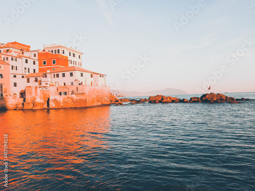 Genova, Italy - February 26, 2021: Beautiful sunset over the sea of Genova in winter days. Amazing red and orange coloured sky reflecting into the water.
