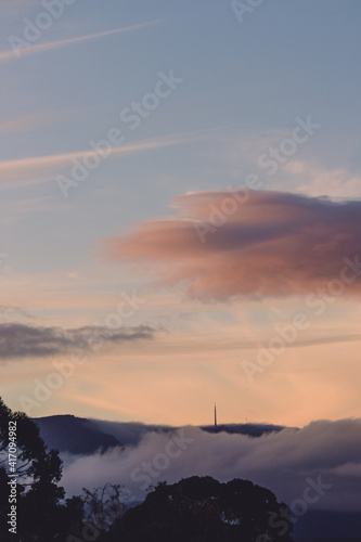 colorful sunset over Mount Wellington in Tasmania, Australia with pink and purple clouds over the mountain and gum trees and vegetation