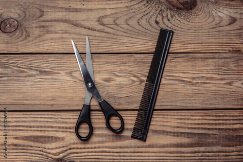 Scissors and hairbrush on wooden table. Set for haircuts, hair care, barbershop