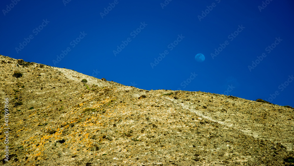 Paisaje árido pero increíblemente hermoso del parque natural del Cabo de Gata, en la costa mediterránea andaluza: El sol y la luna iluminan una duna fosilizada Paisaje árido pero increíblemente hermoso del parque natural del Cabo de Gata, en la costa mediterránea andaluza: El sol y la luna iluminan una duna fosilizada