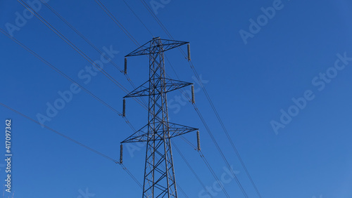 Electricity pylon against deep blue sky with space for copt