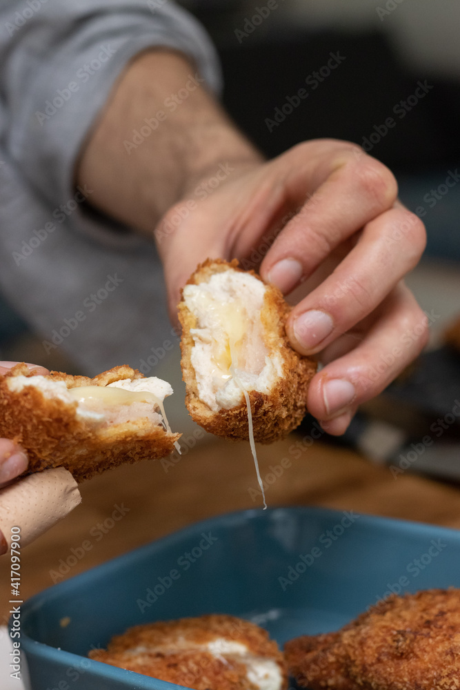 Cooking at home, man opening a chicken nuggets filled with cheese