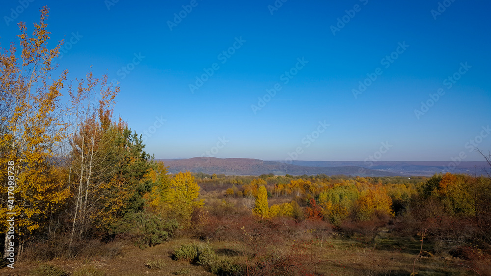 autumn landscape overlooking the horizon where the ridges of the high mountains can be seen. high hills full of dense forests