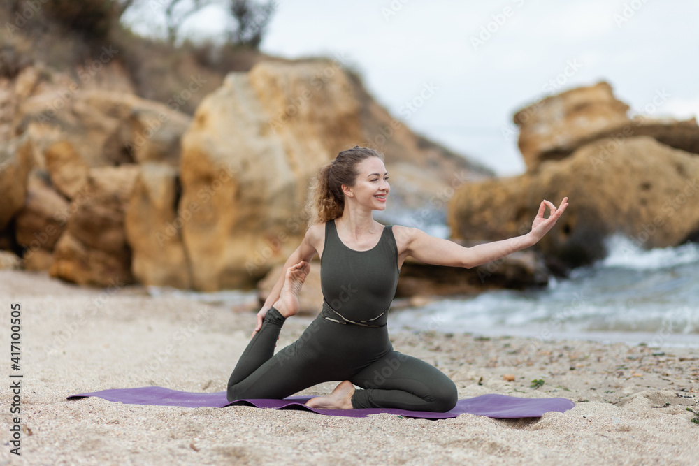 Pretty young healthy yogi woman practicing hatha yoga or asana posture at sea coast with stones. Healthy lifestyle. Pretty young healthy yogi woman practicing hatha yoga or asana posture at sea coast with stones. Healthy lifestyle.