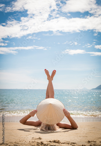 Women body care, pedicure, epilation, beauty, health concept. Close up cropped shot of long female legs with perfect smooth soft skin, getting tanned at beach