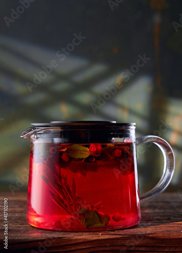 Fruit tea in a glass teapot on a stone background