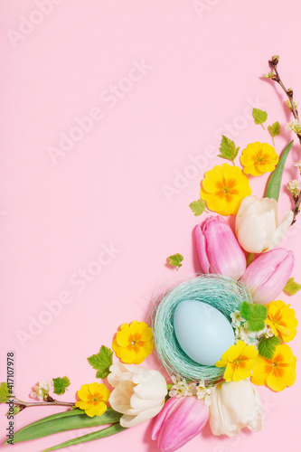 Easter eggs and spring flowers on pink background