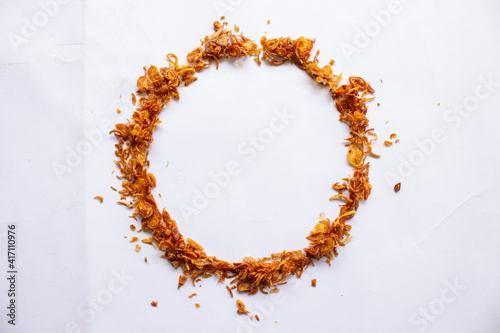 bawang goreng or Pile of fried Indonesian Deep Onion fries  or shallots with circle shape isolated on white background. photo