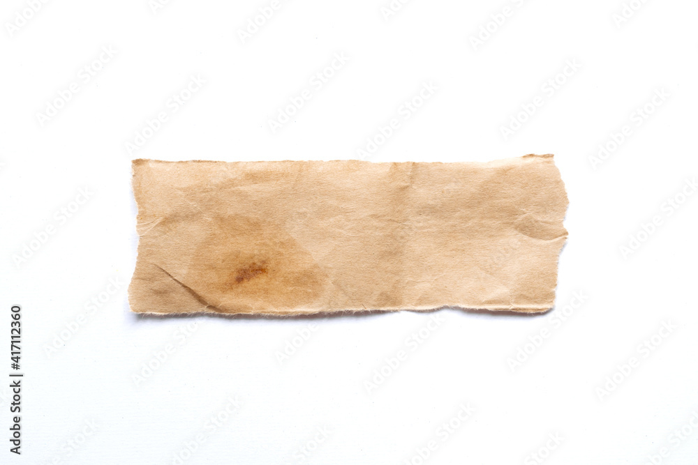 close up of a ripped piece of brown spaper on white background