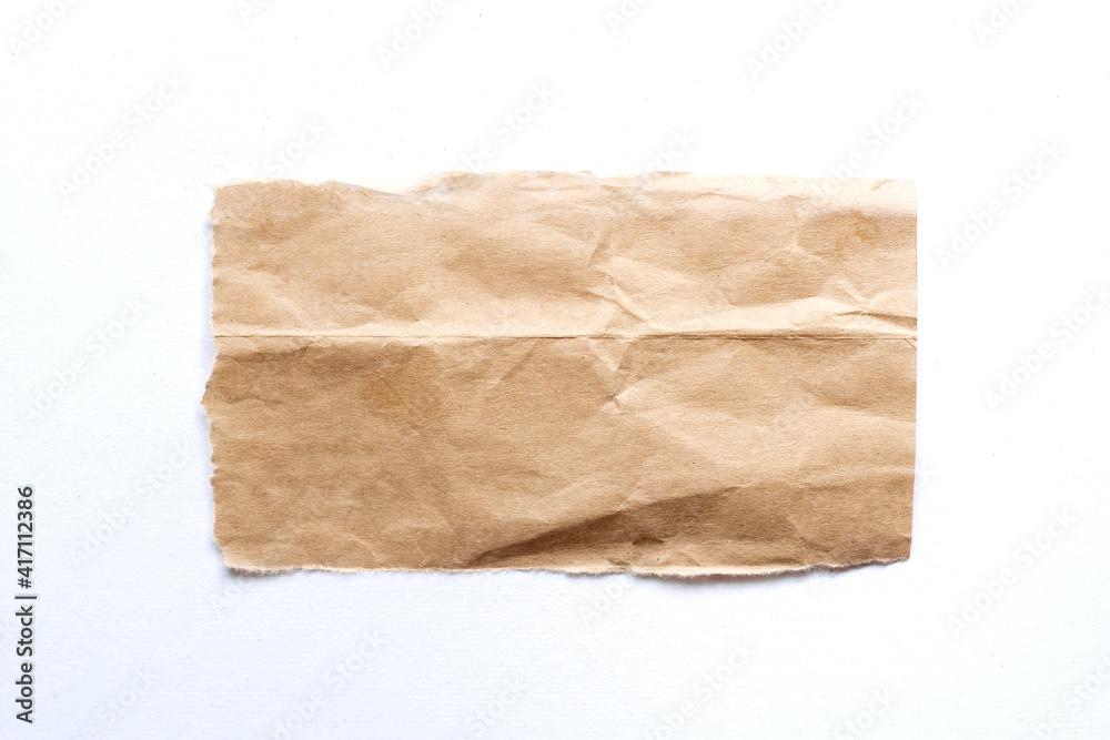 close up of a ripped piece of brown spaper on white background close up of a ripped piece of brown spaper on white background