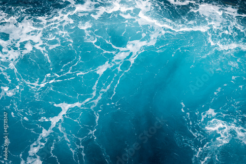Natural background of blue foaming sea water.