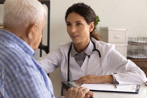 Close up smiling female physician wearing uniform with stethoscope comforting mature patient  sharing good news  medical checkup results  doctor consulting older man at meeting  healthcare concept