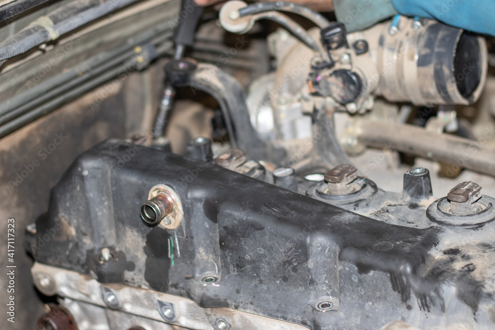 The mechanic is checking the engine.