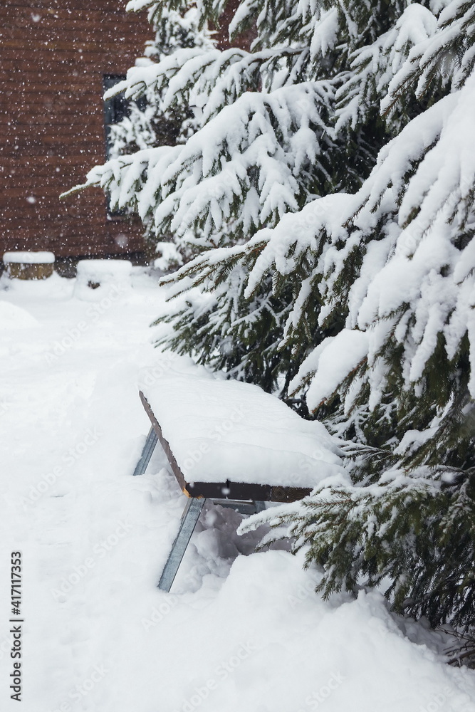 A snowstorm in the mountains sweeps up wooden banches and houses. Wooden banches and Christmas trees in the snow. Carpathians. Ukraine A snowstorm in the mountains sweeps up wooden banches and houses. Wooden banches and Christmas trees in the snow. Carpathians. Ukraine