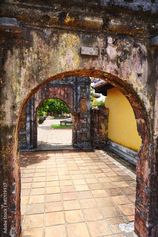 Fototapeta premium Looking through a series of ancient stone arches with tile walkways in between