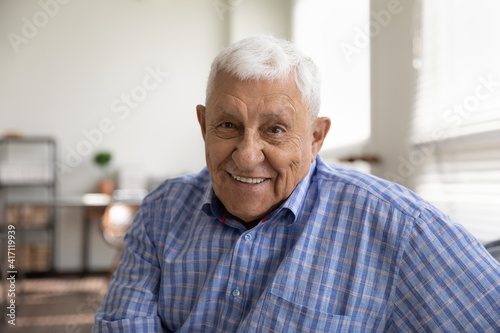 Head shot portrait smiling mature man looking at camera, happy grandfather chatting with relatives online, making video call, senior blogger shooting recording video, elderly teacher working online