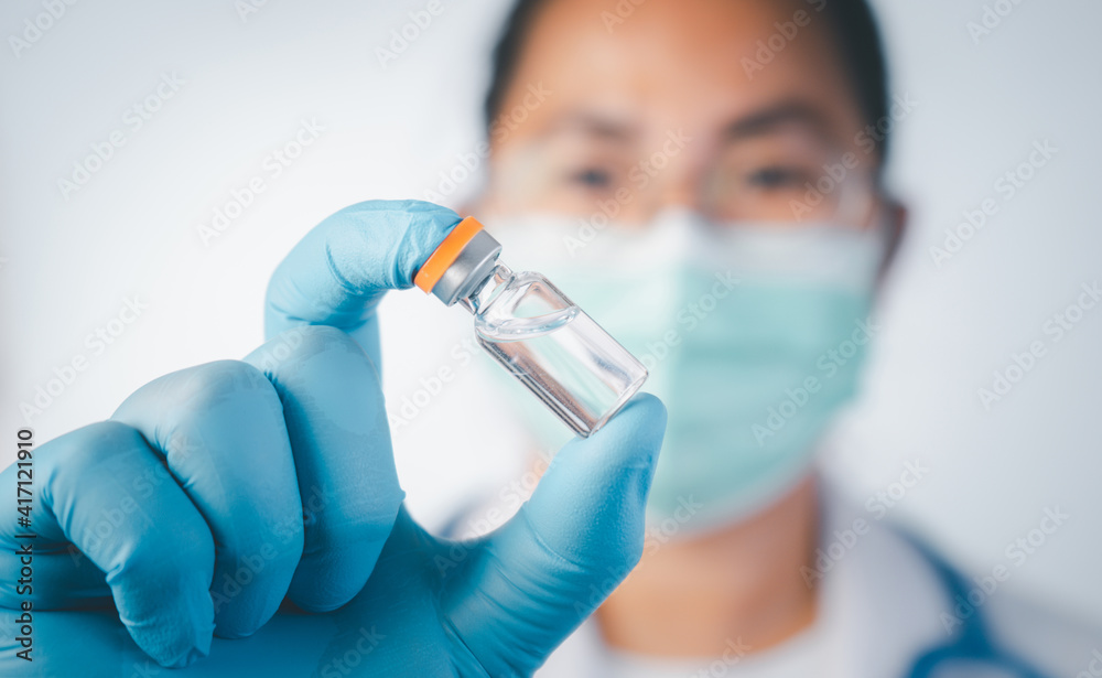 Doctor wear hand in blue gloves holding liquid vaccines,Concept fight against virus covid-19 corona virus Doctor wear hand in blue gloves holding liquid vaccines,Concept fight against virus covid-19 corona virus