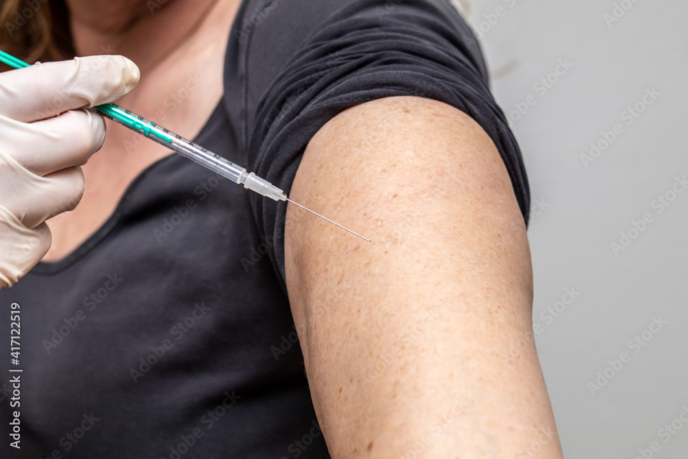 Vaccination with a syringe in the upper arm