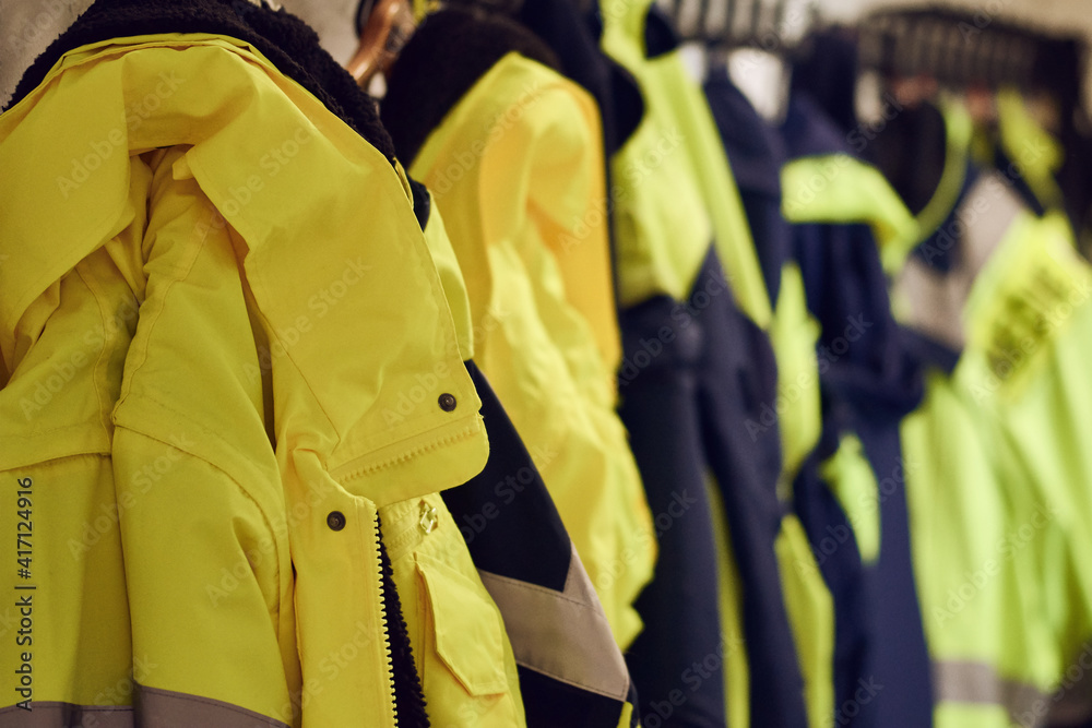 Yellow safety ambulance uniforms hanging in work dressing room
