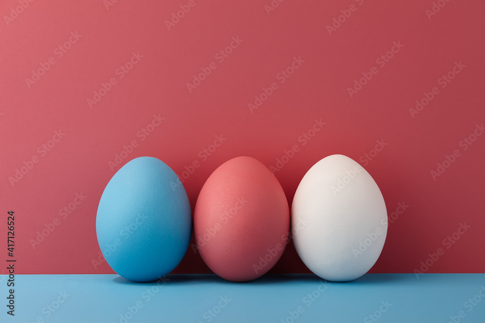 Painted Easter eggs on pink and blue background, spring holiday preparation Painted Easter eggs on pink and blue background, spring holiday preparation