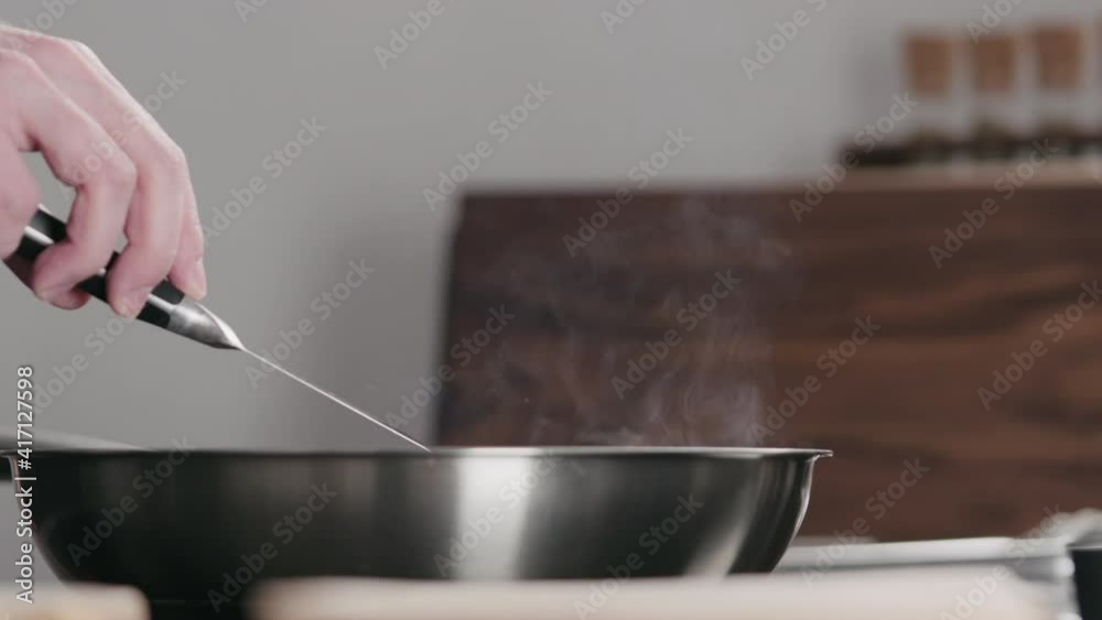 Slow motion man rub steak with butter during cooking in steel pan Slow motion man rub steak with butter during cooking in steel pan
