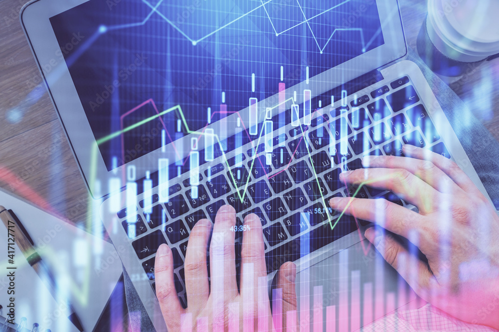 Double exposure of man's hands typing over computer keyboard and forex graph hologram drawing. Top view. Financial markets concept. Double exposure of man's hands typing over computer keyboard and forex graph hologram drawing. Top view. Financial markets concept.