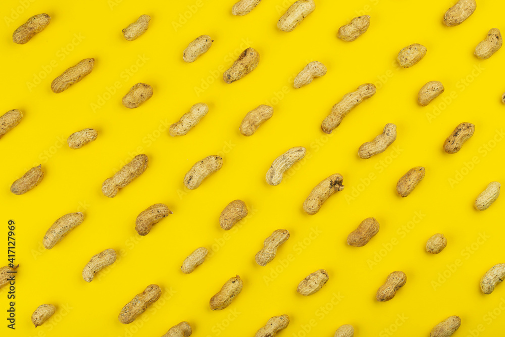 Peanuts pattern isolated on a yellow backround. Repetition concept.