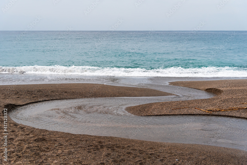 Small meander of a stream when it reaches the sea.