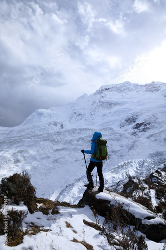 Successful woman backpacker hiking in winter mountains